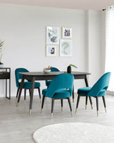 Contemporary dining room furniture featuring a rectangular, dark wood table with sleek lines and four teal upholstered chairs with black legs tipped with gold accents. A matching dark wood console table is visible in the background.