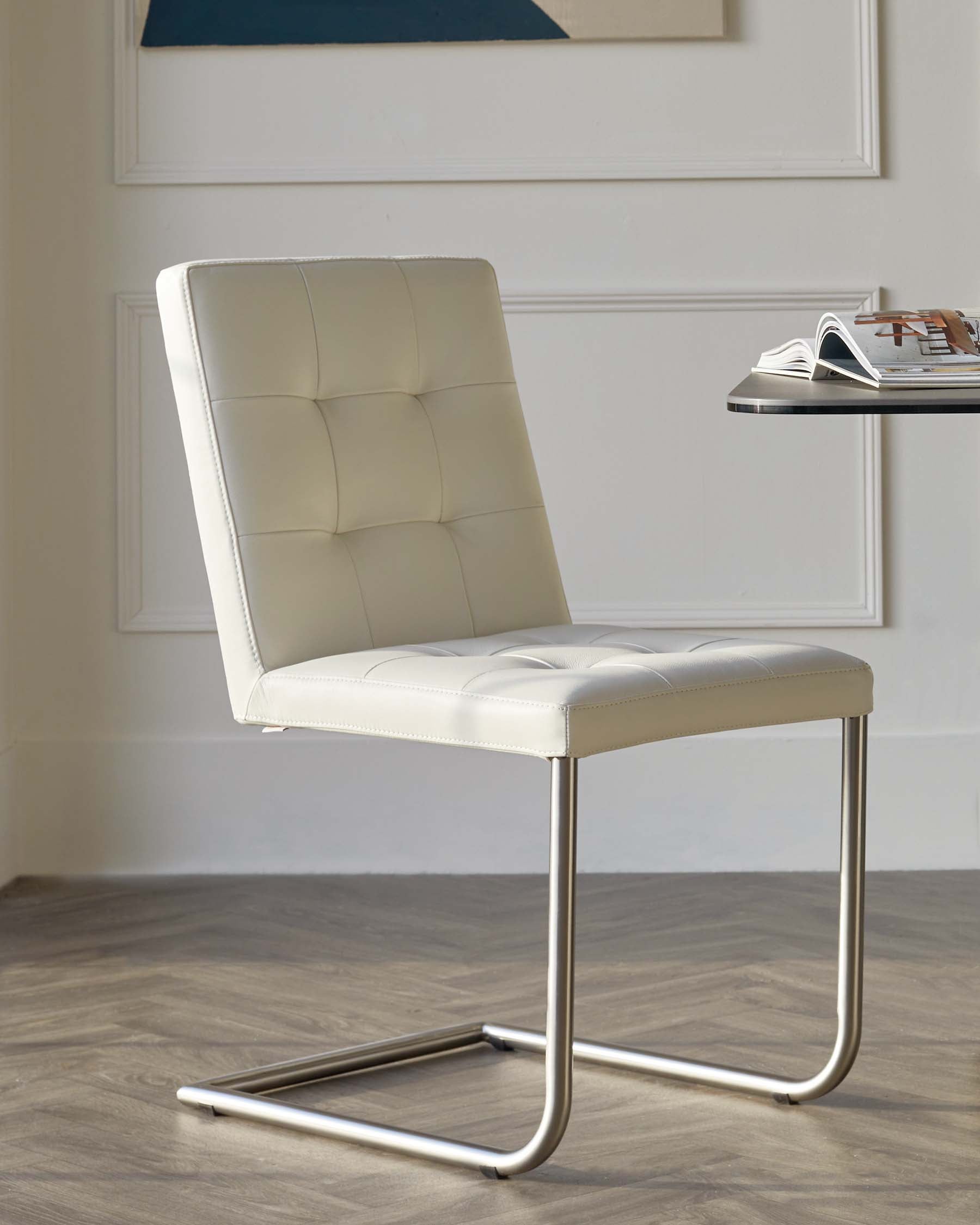 Modern cream-colored leatherette cantilever chair with a tufted backrest and seat, featuring a sleek chrome base.