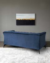 Elegant blue velvet upholstered bench with tufted detailing and dark tapered wooden legs, positioned on a textured off-white area rug.