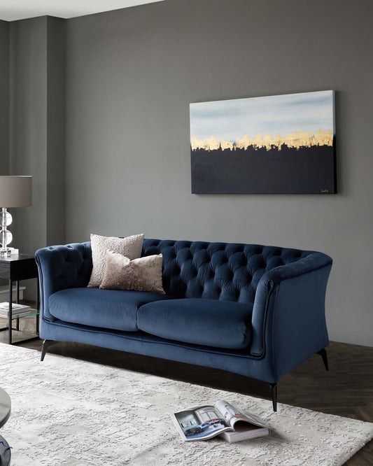 Elegant navy blue velvet sofa with tufted backrest, featuring dark wood legs, complemented by a variety of textured cushions.