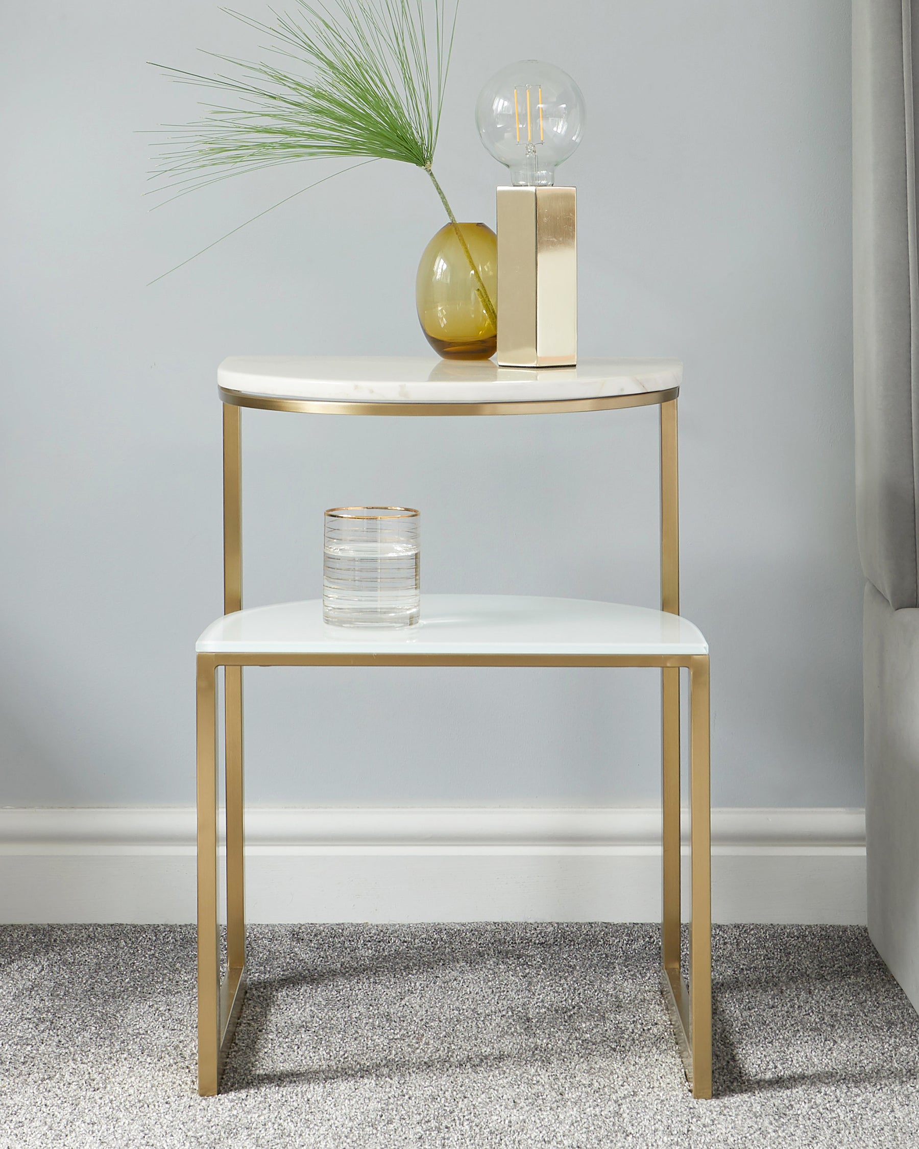 Elegant contemporary two-tier round side table with a white tabletop and gold-finished metal frame, featuring sleek lines and a minimalistic design.