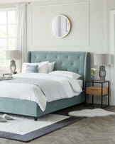 Elegant tufted teal upholstered bed with a high headboard, accompanied by a sleek black metal nightstand featuring a wooden drawer. A contemporary white and grey area rug is partially underneath the bed.