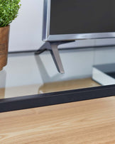 Modern minimalist TV stand with a sleek metal frame and a smooth wooden surface.