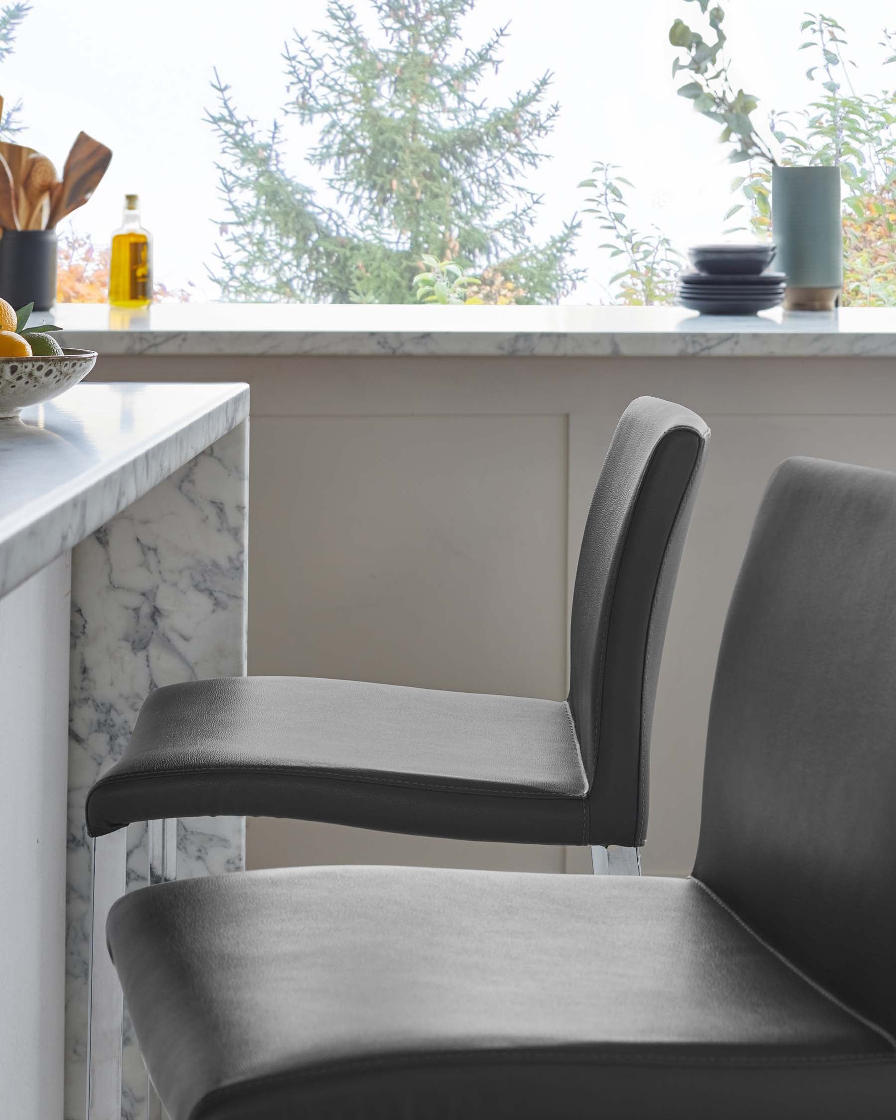 Modern grey upholstered dining chair with a curved backrest and cushioned seat.