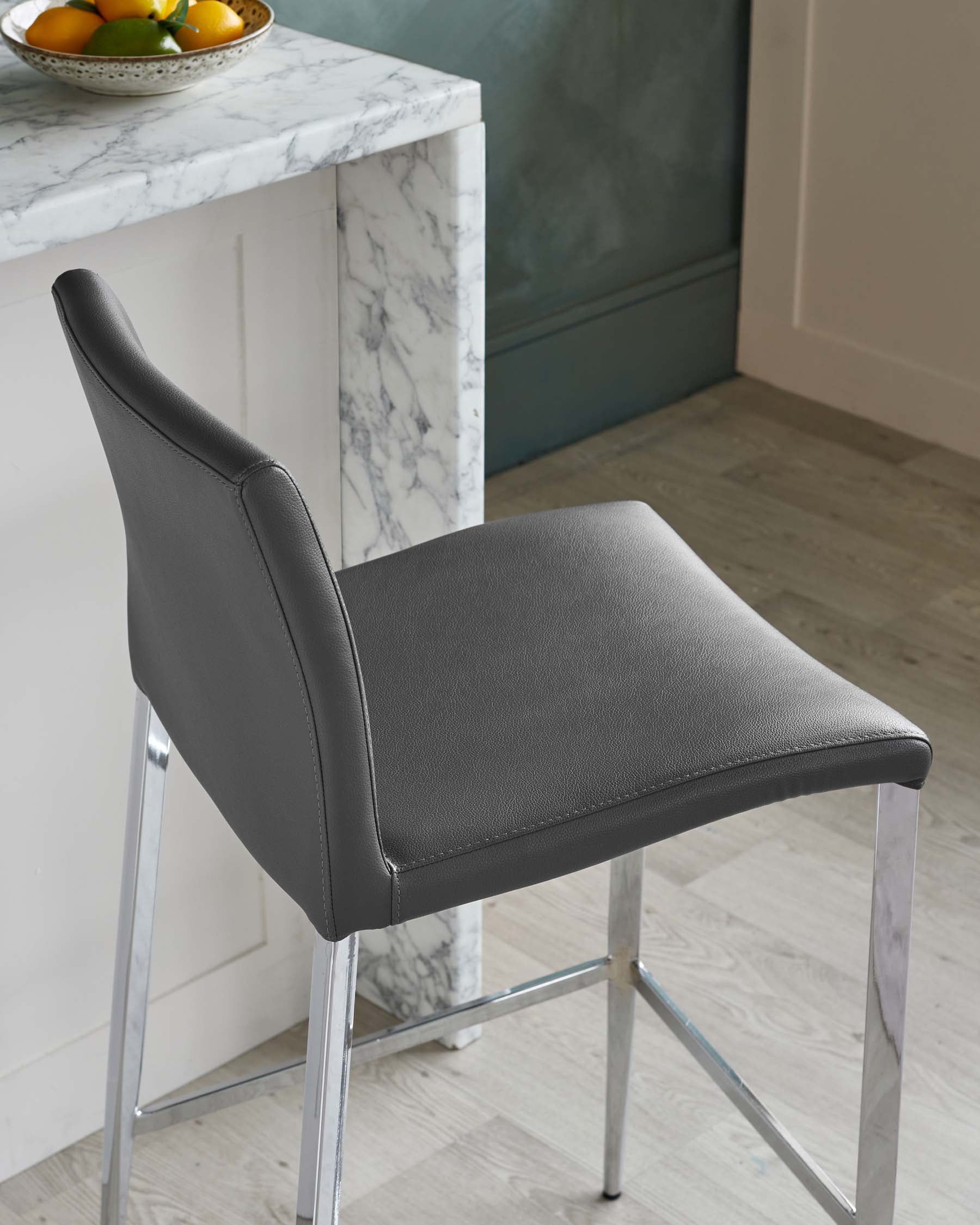 Modern black leatherette dining chair with a sleek chrome frame and a minimalistic design.