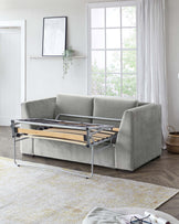 Modern light grey fabric sofa with a pull-out bed mechanism featuring a metal frame and wooden slats, showcased in a bright room with natural light.