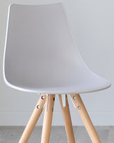 Modern minimalist design chair with a white moulded plastic seat and wooden legs, reinforced by black metal brackets.