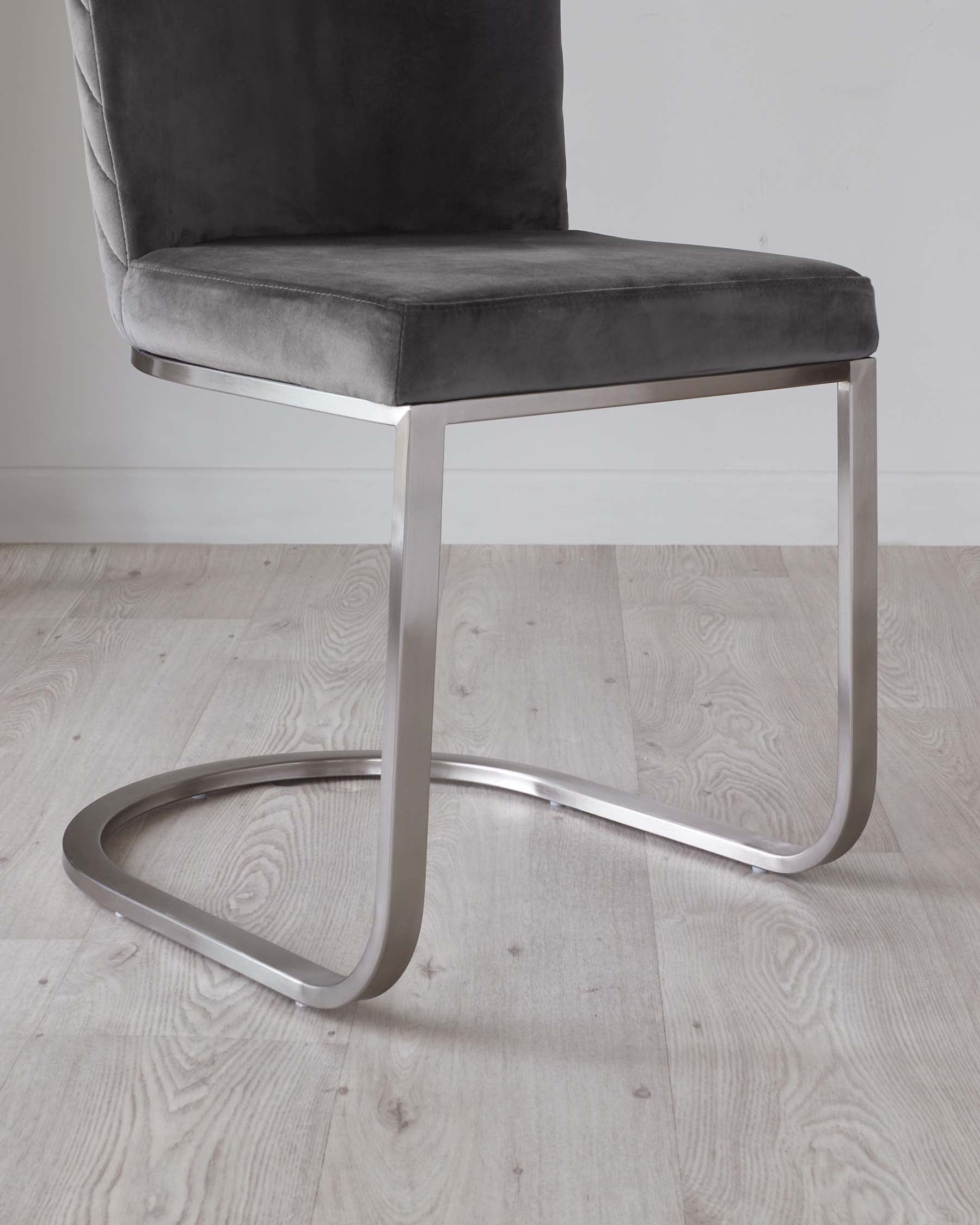 Modern cantilever chair with a brushed silver metal frame and plush grey velvet upholstery.