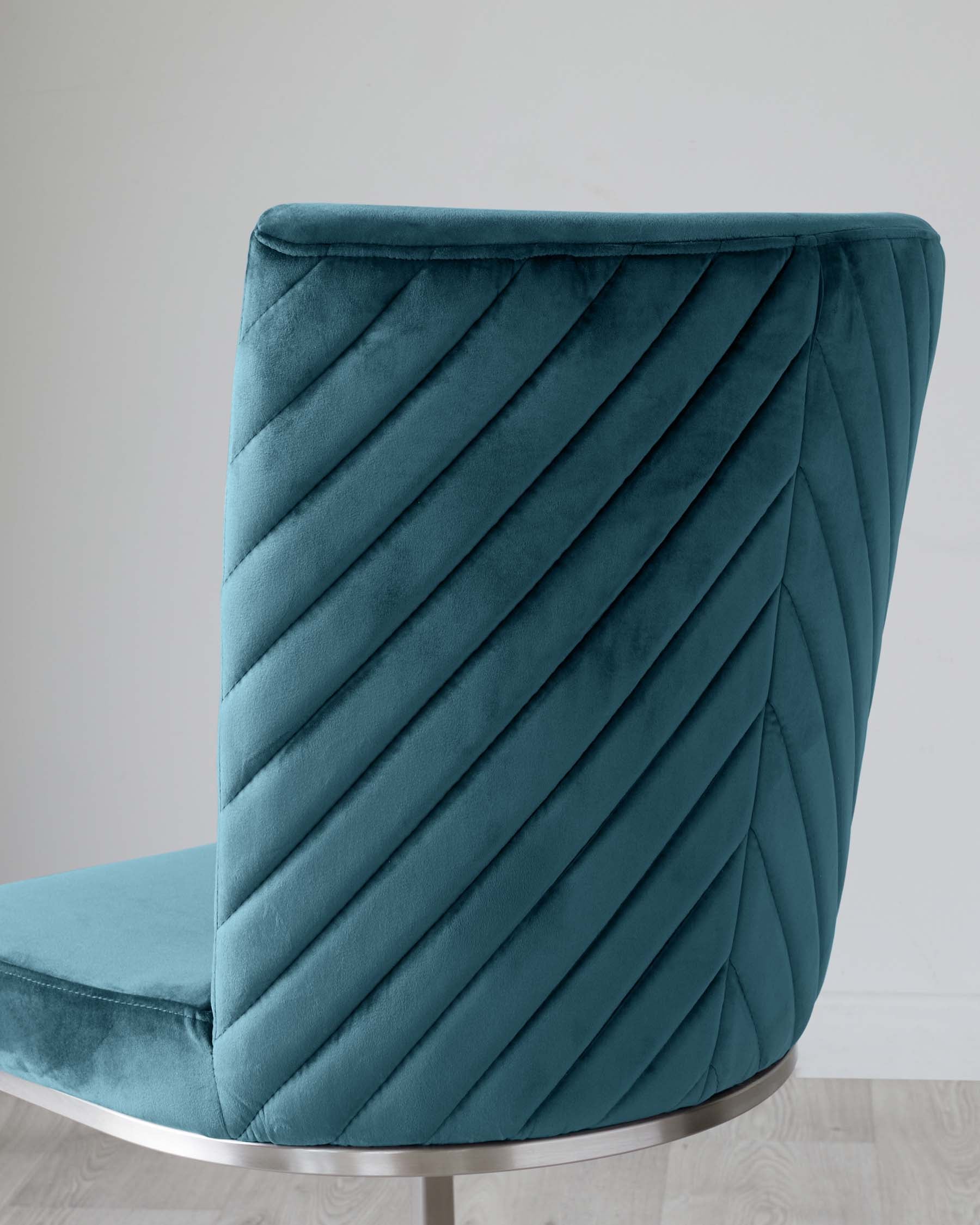 Modern teal velvet accent chair with a curved backrest featuring elegant diagonal channel tufting and a sleek metallic base.