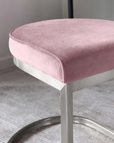 Modern chic blush pink velvet cushioned stool with sleek, silver-finished metal legs and a circular base.