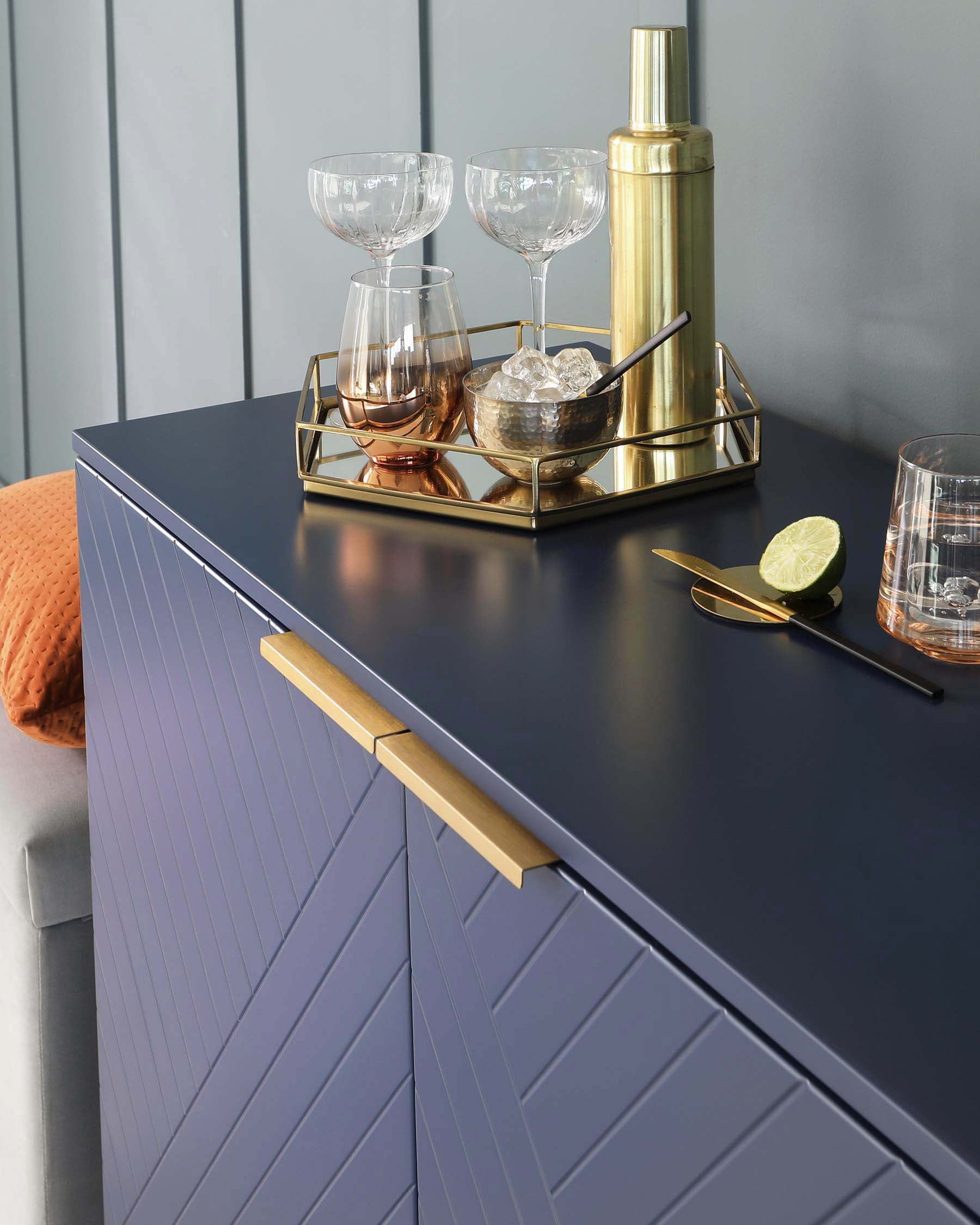 Modern navy blue sideboard with chevron-patterned front panels and gold-tone handles.