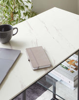 Modern rectangular table with a white marble patterned top and sleek black metal legs.