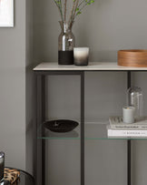 Contemporary bookshelf with a faux marble top, complemented by a sleek metal frame in a grey finish. Includes several open shelves with one featuring a glass insert, perfect for displaying books and decorative items.