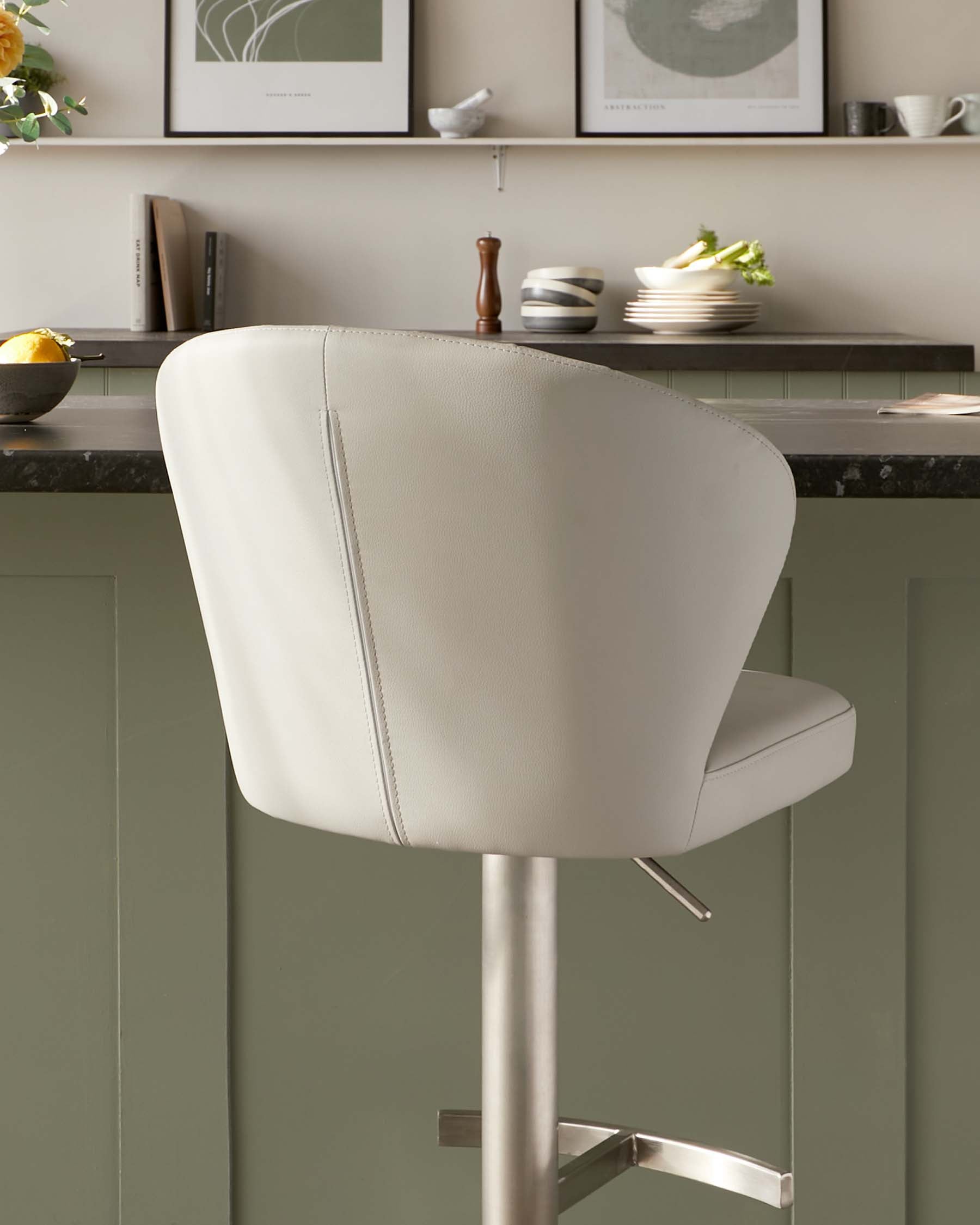 Modern adjustable-height bar stool with a curved backrest and cushioned seat, upholstered in light grey leather with visible stitching details, mounted on a sleek chrome pedestal base with a footrest.