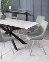 Modern dining room set with a white marble-top table with angular black metal legs and four sleek, light grey upholstered chairs with slender metal legs. A minimalist console table with a dark wooden top and black metal frame is against the wall, adorned with decorative items including candles and glassware. The setting is complemented by a pale grey rug and soft teal walls.