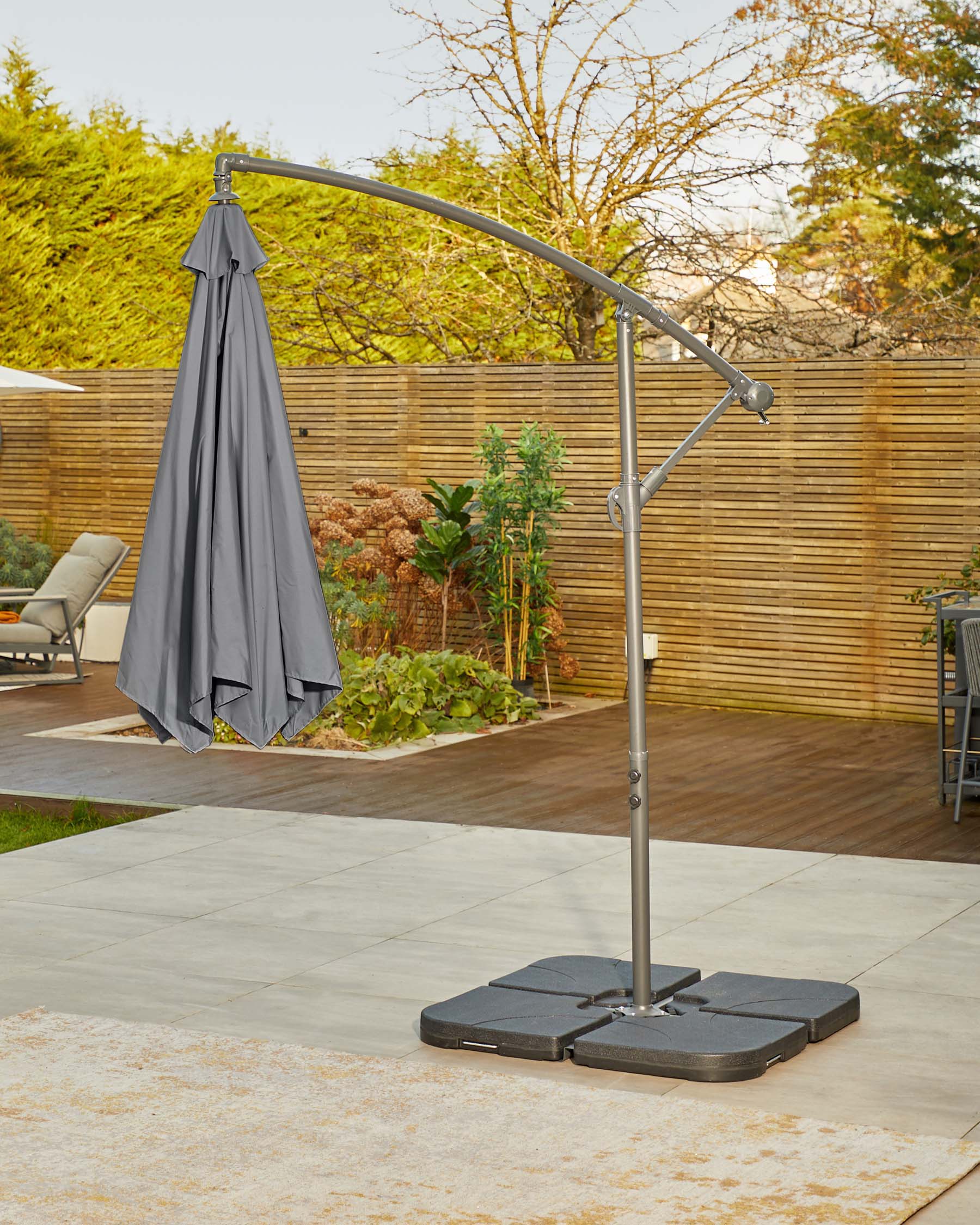 A modern outdoor umbrella stand with a sleek, gray canopy and a sturdy black base, ideal for patio or garden settings.