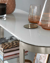 Elegant white round table with a high-gloss finish and silver metal legs.