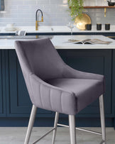 Elegant contemporary bar stool with a smooth grey fabric upholstery, featuring a gently curved backrest and a comfortable seat. The chair has a sleek, supportive metal frame with a slender, four-legged base.