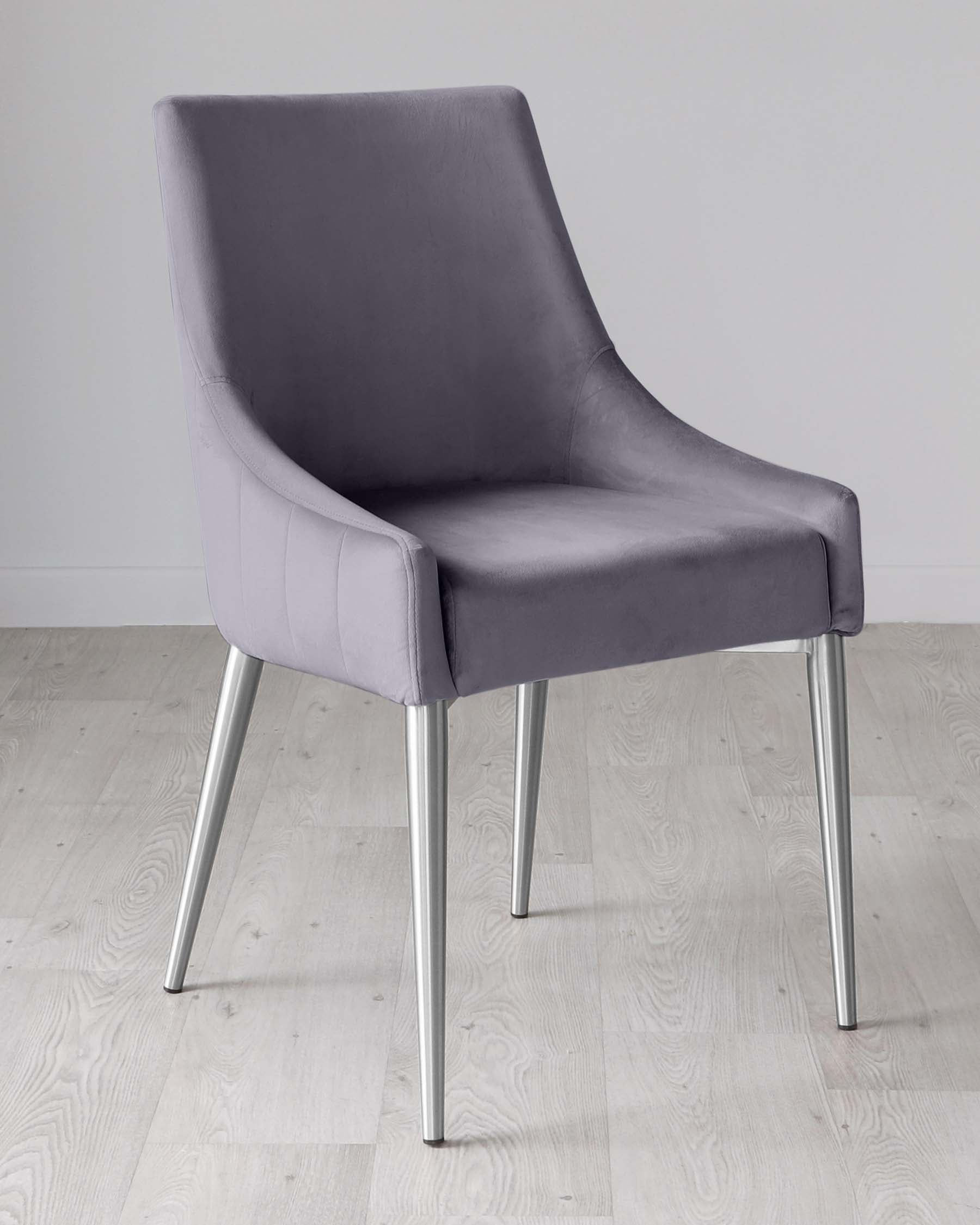 Modern grey upholstered dining chair with high back and curved armrests on sleek metallic legs, presented on a light wood floor against a white backdrop.