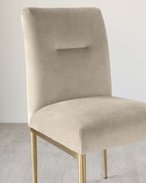 Elegant modern dining chair with a sand-coloured velvet upholstery and brass-finished metal legs. The chair features a clean-lined rectangular back with a subtle cut-out detail, providing both comfort and contemporary style.