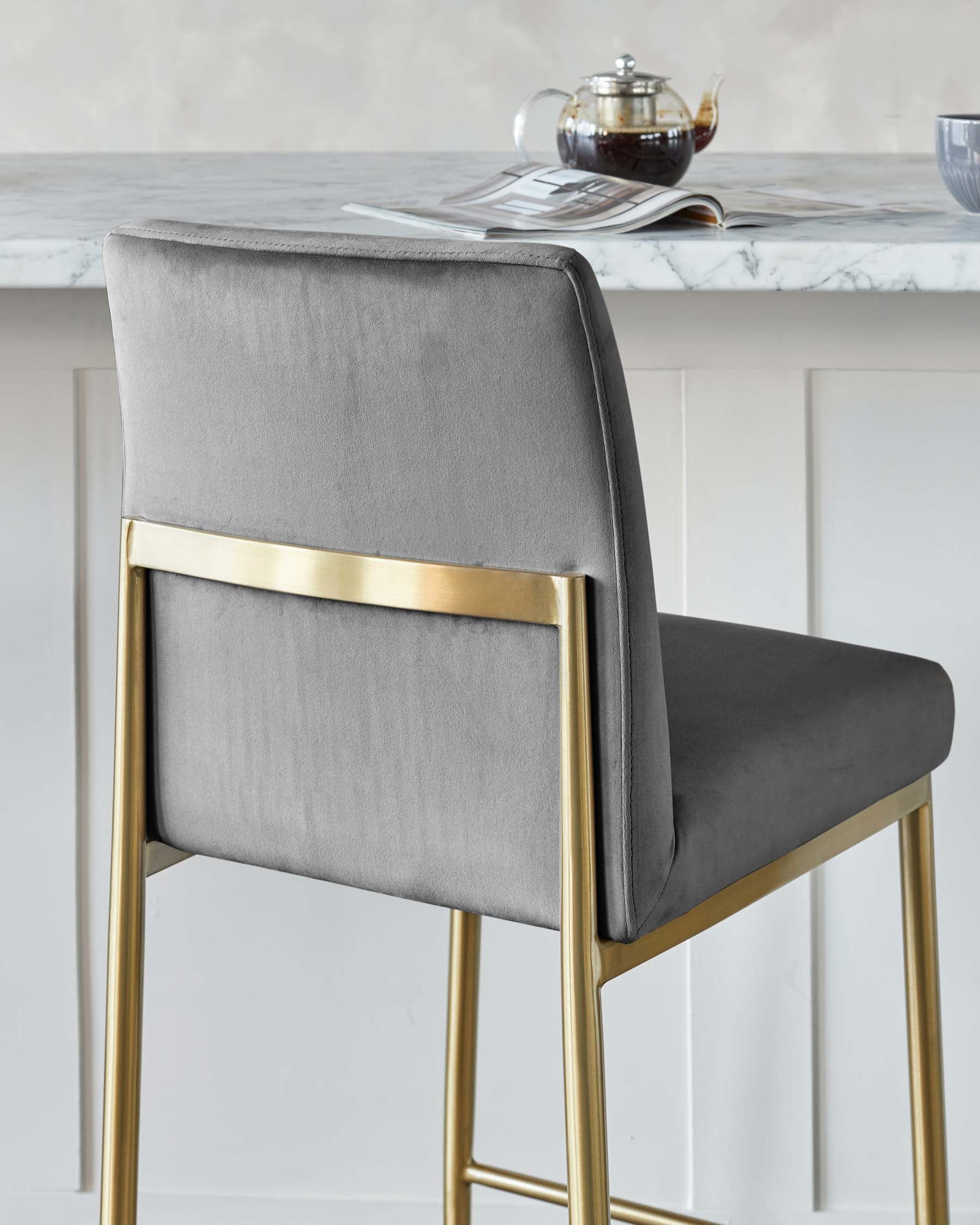 Modern grey upholstered bar stool with a sleek gold metal frame.