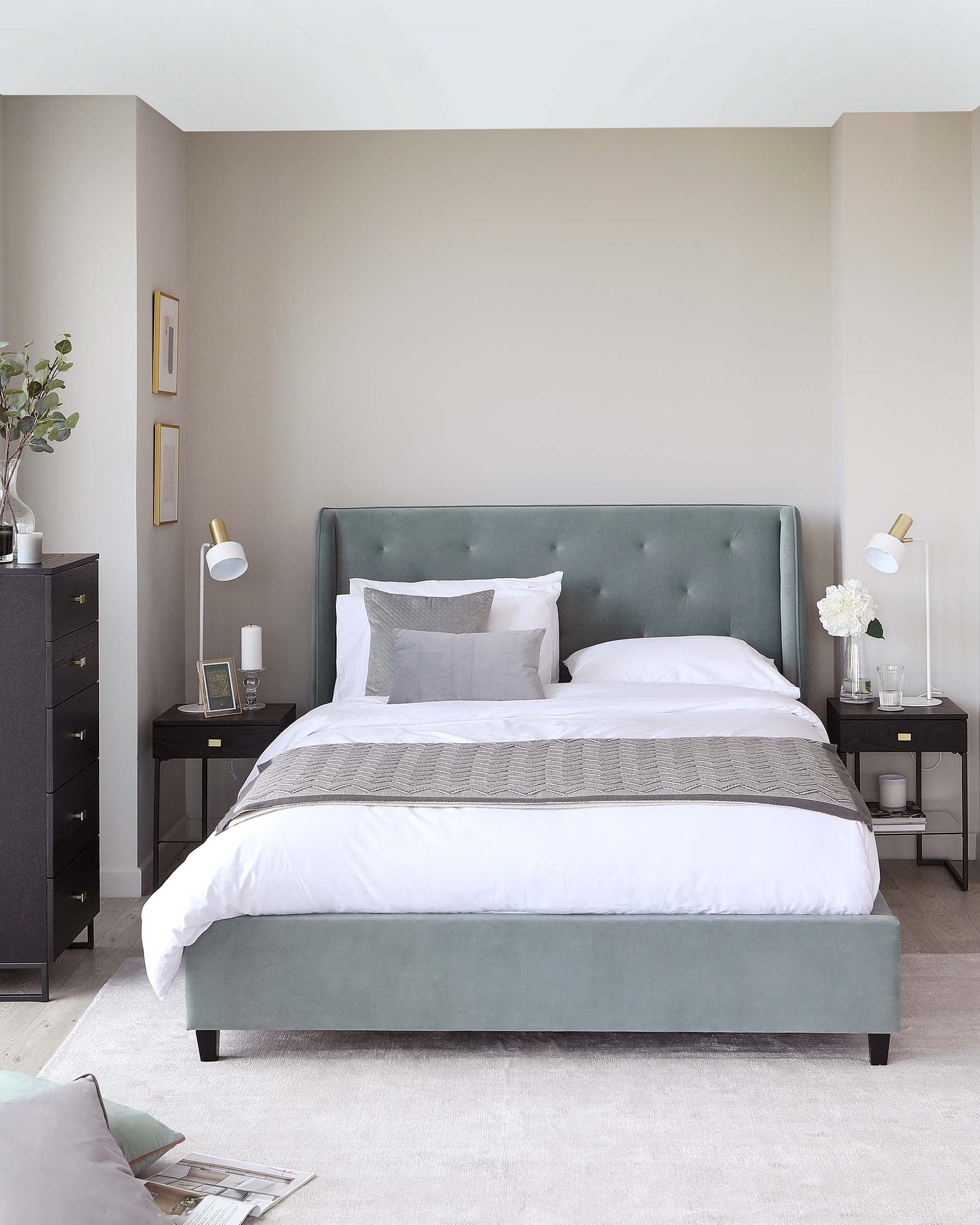 Elegant bedroom featuring a queen-sized bed with a tufted, wingback headboard in a soft, sage green upholstery. The bed is dressed with crisp white linens, a plush grey throw, and assorted pillows. Flanking the bed are two matching black nightstands with thin, tapered legs, each adorned with a white lamp, books, and minimalistic decorative items. A muted floor rug under the bed adds a cosy touch to the room.