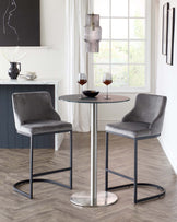 Modern dining set featuring a round-top bistro table with a sleek chrome base, paired with two sophisticated grey velvet bar chairs with angular metal legs.