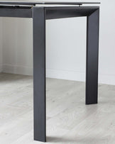 Modern minimalist black metal console table with a slender silhouette and clean lines, set against a neutral background.