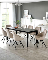 Elegant dining room set featuring a modern black rectangular table with sleek metal legs, surrounded by eight plush, light beige upholstered chairs with black metal legs, arranged on a light hardwood floor. The dining set is complemented by a contemporary metal chandelier above and styled with a textured ceramic vase, decorative greenery, and scattered tableware.