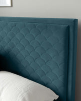 Elegant teal upholstered headboard featuring a plush tufted design with scalloped detailing and curved edges, presented against a neutral wall background with a partial view of a pillow.