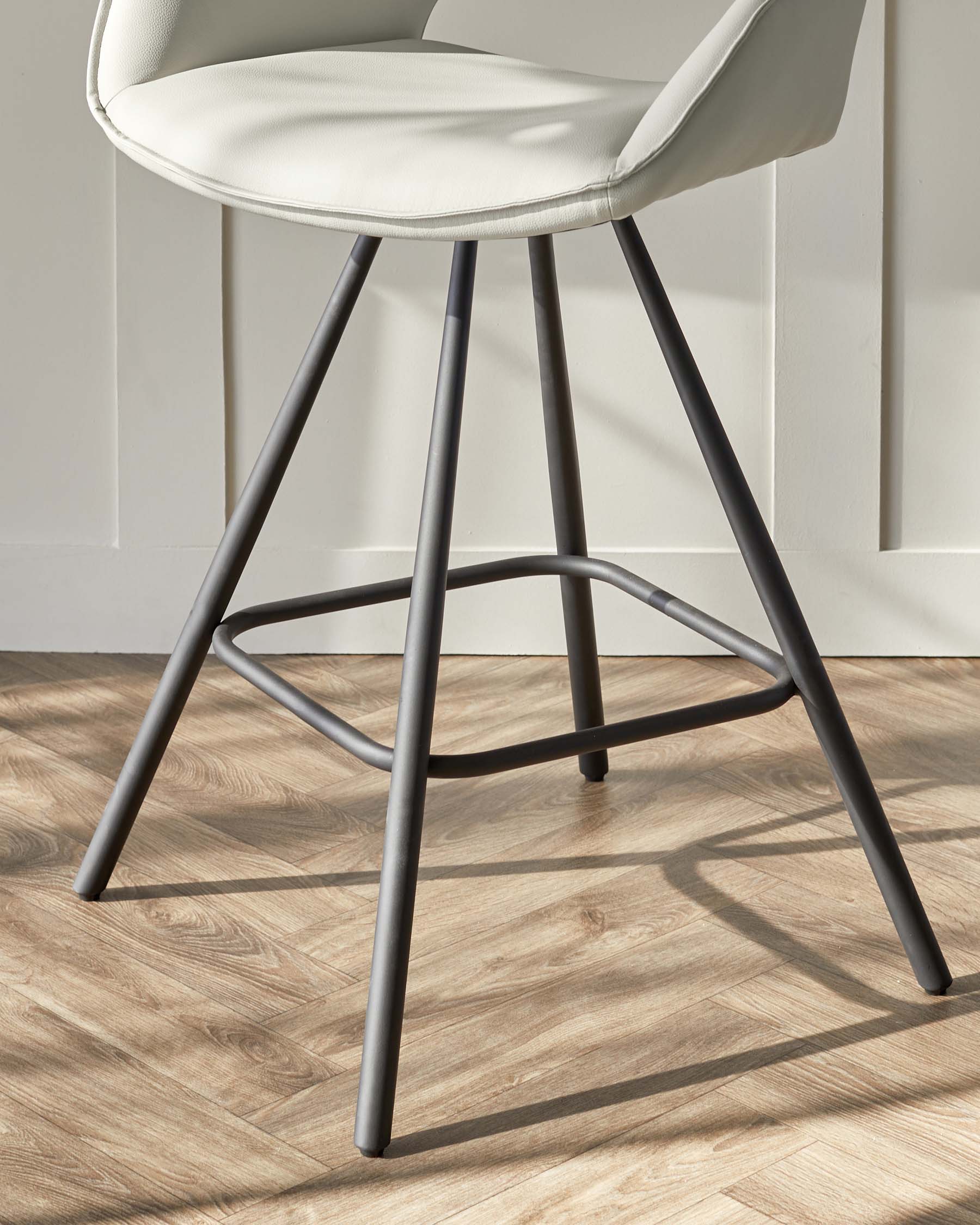 Modern minimalist bar stool with a cream upholstered seat and a matte black metal frame with slender legs and footrest.