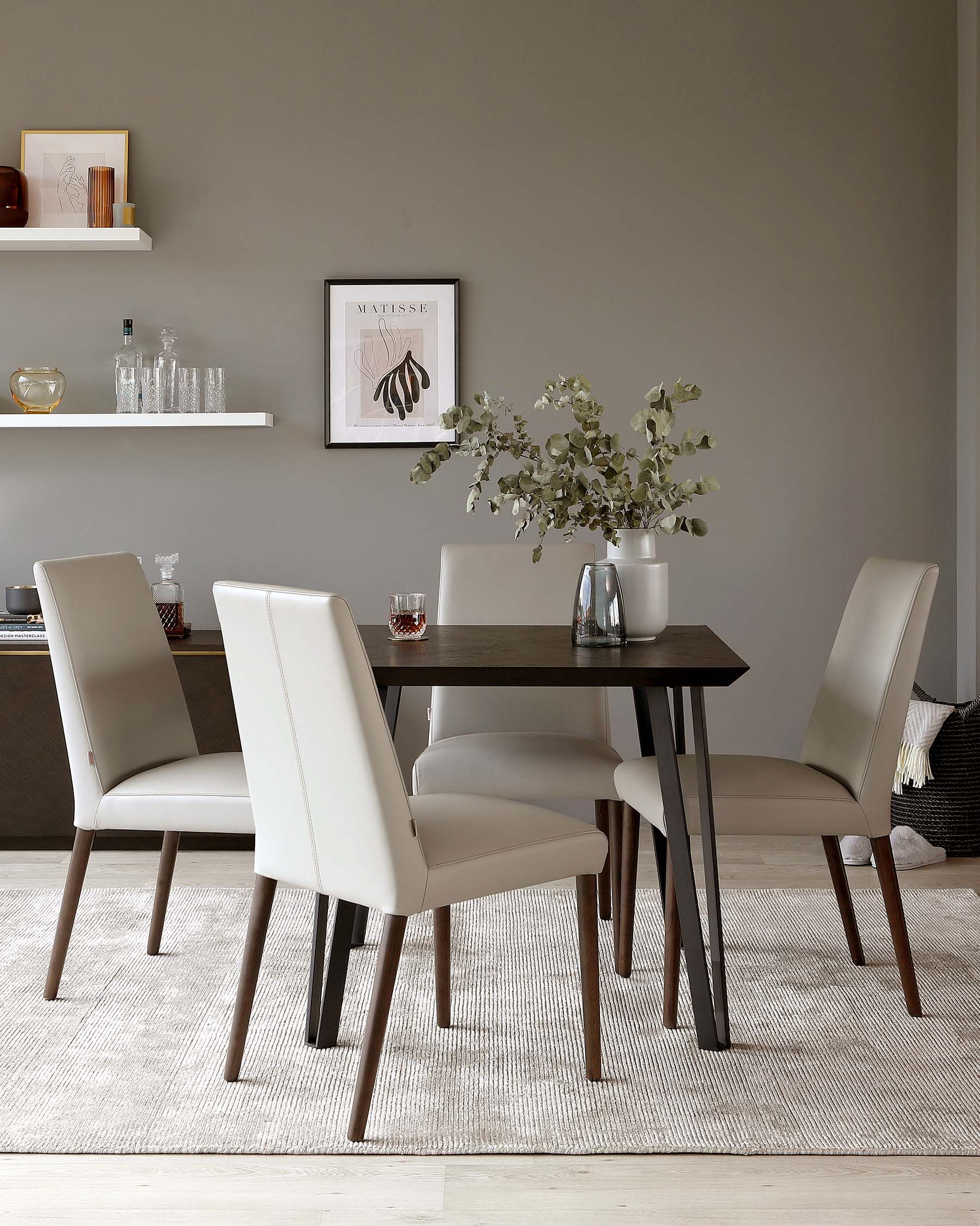 A modern dining set featuring a dark wooden table with a straight clean-lined design and four cream upholstered chairs with a sleek silhouette and dark wooden legs. The set is arranged on a textured off-white area rug, enhancing the contemporary feel of the setup.