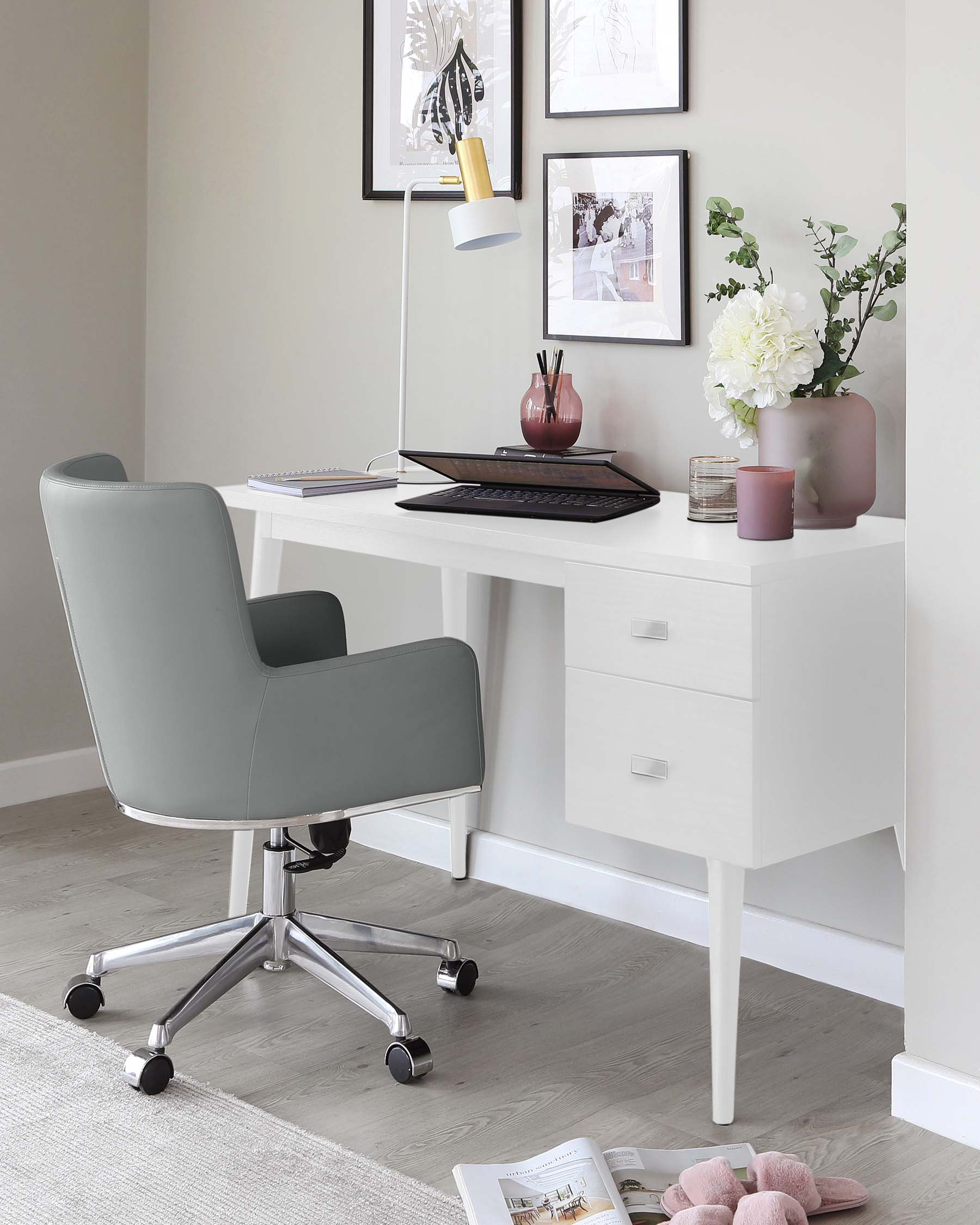 Modern minimalist home office furniture set with a sleek white writing desk featuring clean lines, two drawers for storage, and a spacious tabletop. Accompanied by a contemporary grey upholstered office chair with a curved backrest, mounted on a five-caster chrome base for mobility.