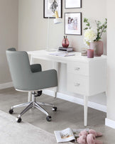 A modern home office setup featuring a sleek white desk with two drawers, paired with a minimalist grey upholstered office chair with a curved back and metallic wheeled base. The clean lines and neutral tones create an inviting workspace.