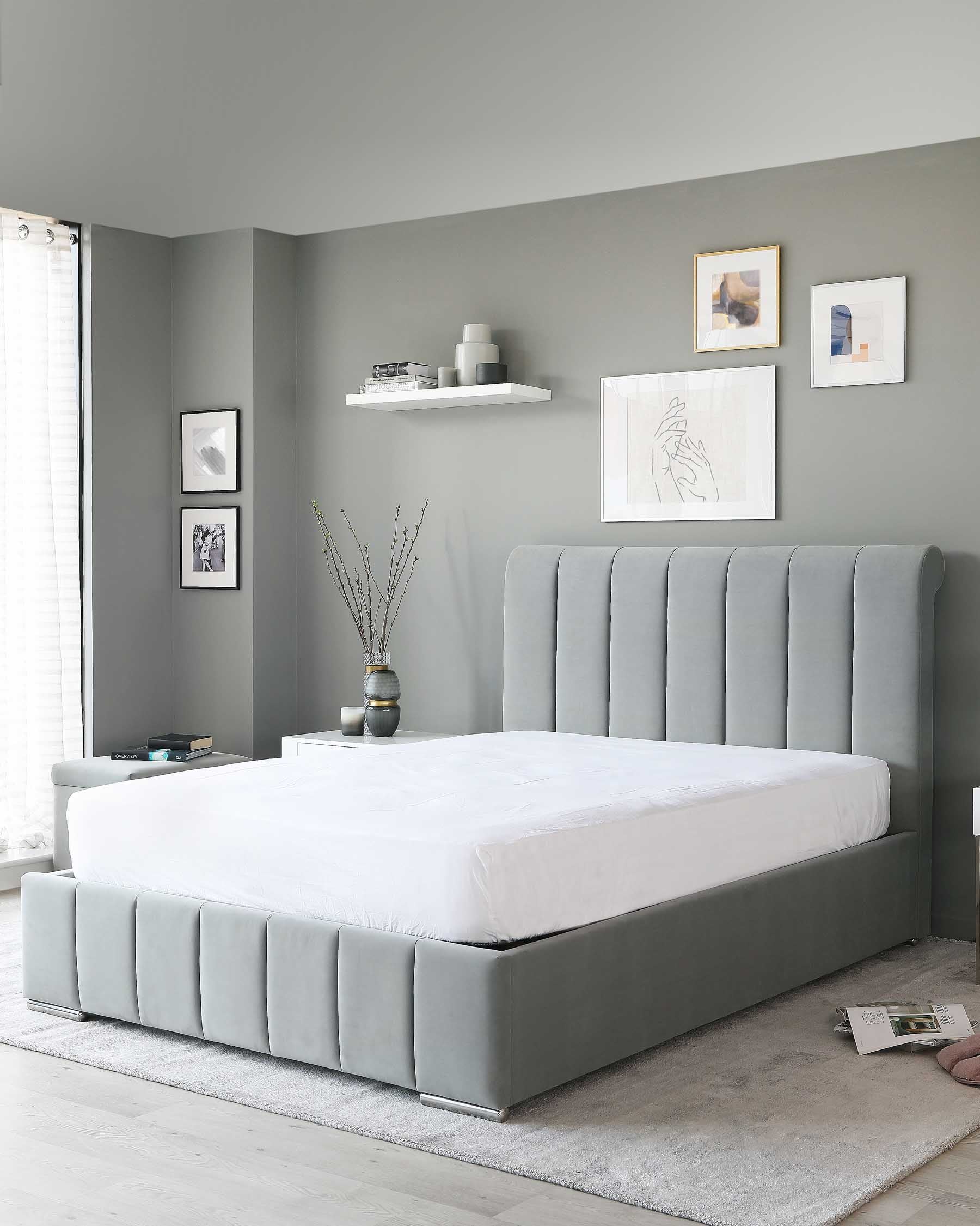 Gray upholstered platform bed with an extended vertical channel-tufted headboard, accompanied by a light grey area rug beneath it.