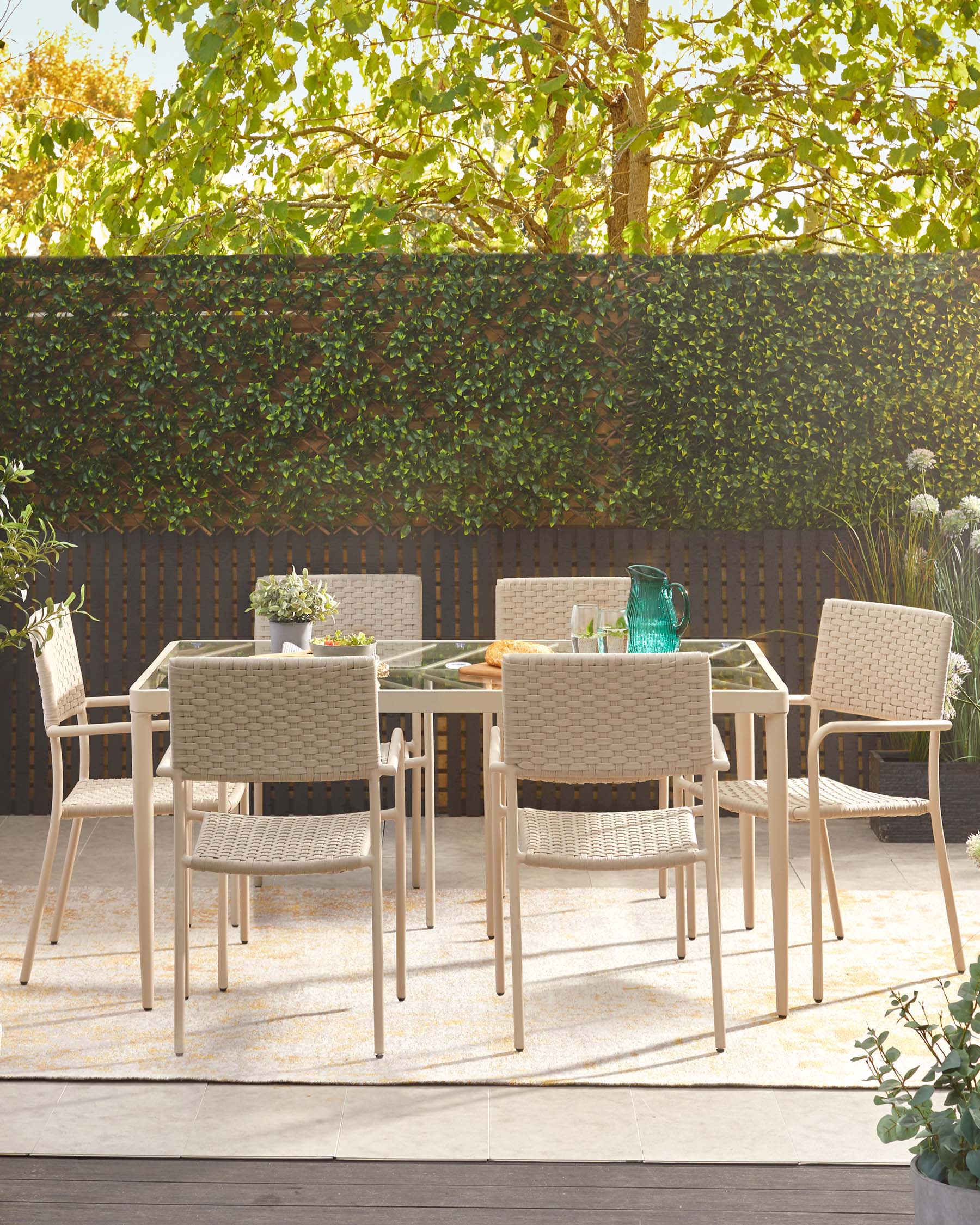 Outdoor furniture set consisting of a modern, rectangular glass-topped table and six woven chairs with metal frames, displayed on a patio.