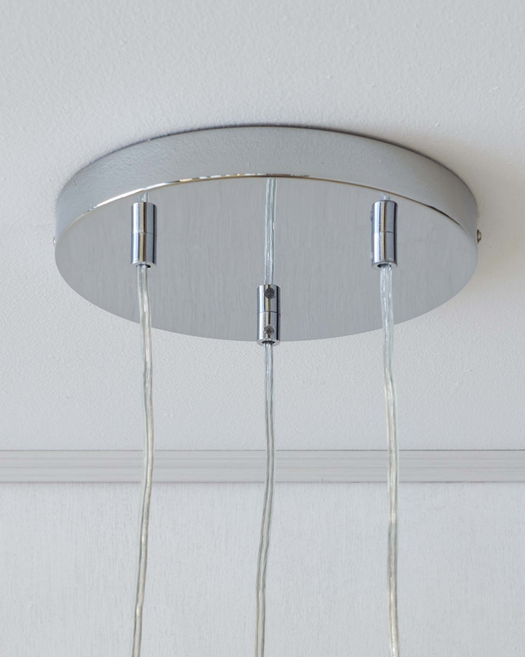 Contemporary silver ceiling lamp with a metallic, circular base and multiple suspended cables.