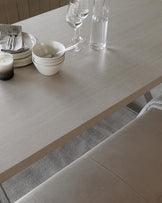 Modern light wood dining table with textured finish and a minimalist design, paired with a sleek fabric-upholstered bench in a complementary colour.