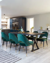 Contemporary dining set featuring a rectangular, dark wood table with a unique, crisscross leg design and six plush, teal velvet chairs with black legs accented by gold tips.