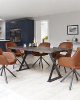 Modern dining room set comprising a rectangular wooden table with a smooth dark finish and angular metal legs, accompanied by six mid-century inspired chairs with sleek caramel-coloured leather upholstery and dark metal legs.