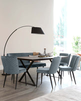 A modern dining set with a rectangular table, upholstered chairs, and a stylish arc floor lamp in a bright, airy space.