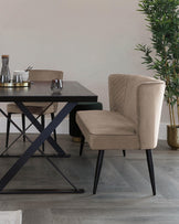 Modern dining area featuring a dark wood rectangular table with black crossed-leg metal base, and a beige upholstered chair with channel tufting and black tapered legs.