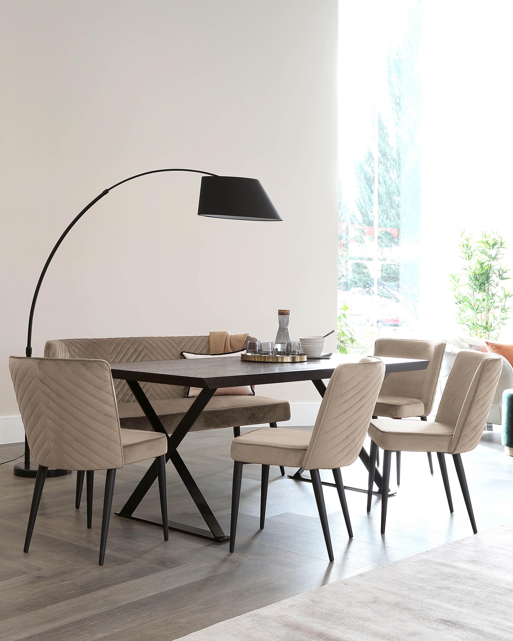 Modern dining room setting featuring a dark wooden rectangular table with X-shaped metallic legs, complemented by four elegant, upholstered dining chairs with quilted backrests and slender black legs. A large, arc floor lamp with a black shade looms overhead, adding a contemporary touch to the scene.