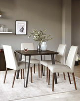 Modern dining set featuring a dark brown square wooden table and four cream upholstered chairs with sleek brown wooden legs, arranged on a light grey area rug.