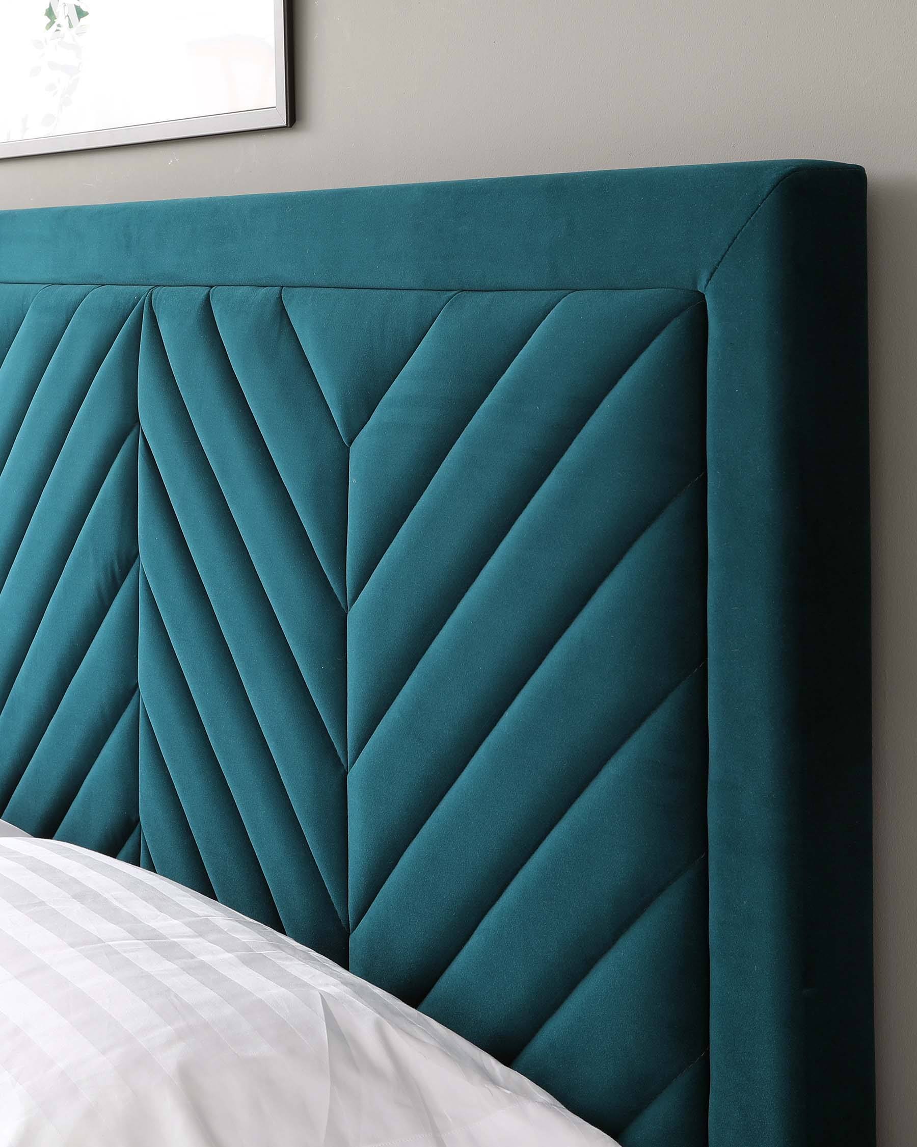 Elegant teal upholstered headboard featuring a geometric chevron pattern with plush padding, providing both comfort and sophisticated style for a bedroom setting.