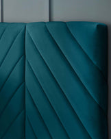 Textured teal upholstered headboard with elegant diagonal stitching, designed for a modern and stylish bedroom.