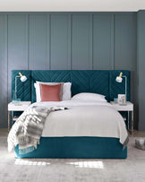 A stylish teal bed with a chevron headboard, white bedding, a gray throw, side tables with lamps, and modern decor.