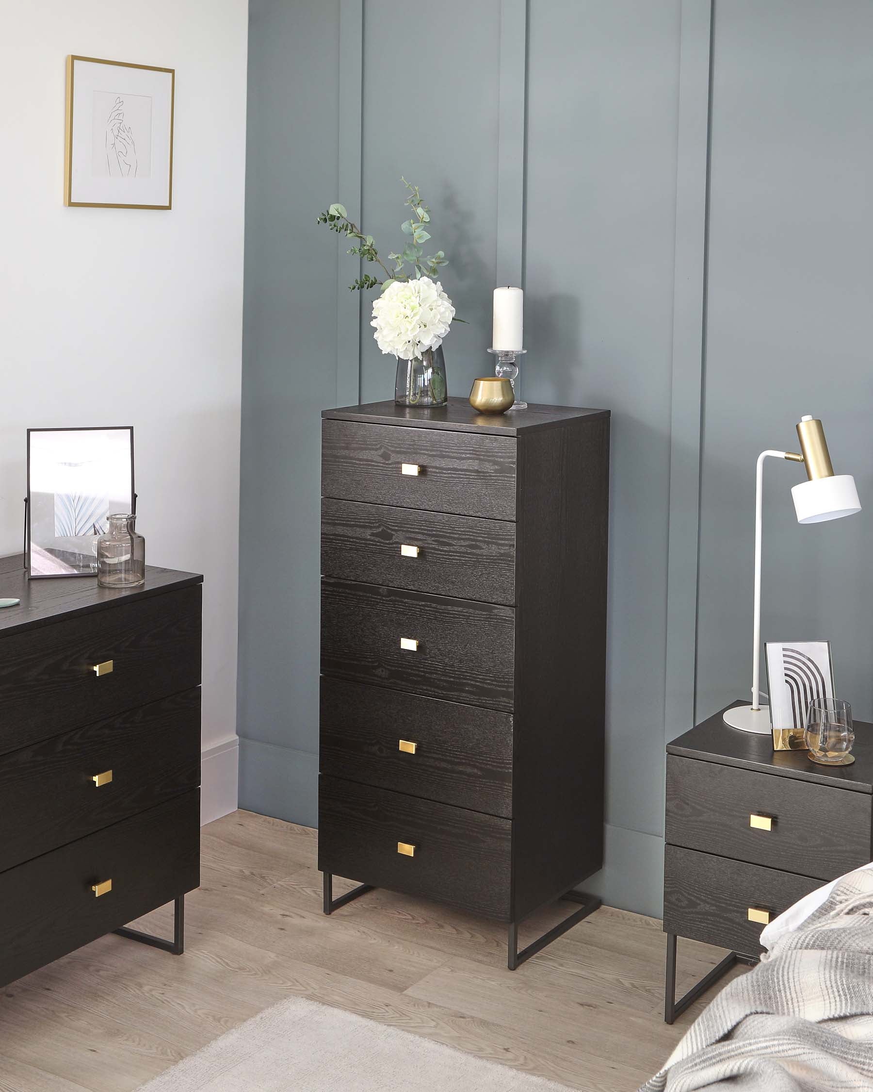 A modern bedroom furniture set featuring a tall, narrow five-drawer dresser and a shorter three-drawer chest, both in a dark wood finish with gold-coloured metal handles and legs.