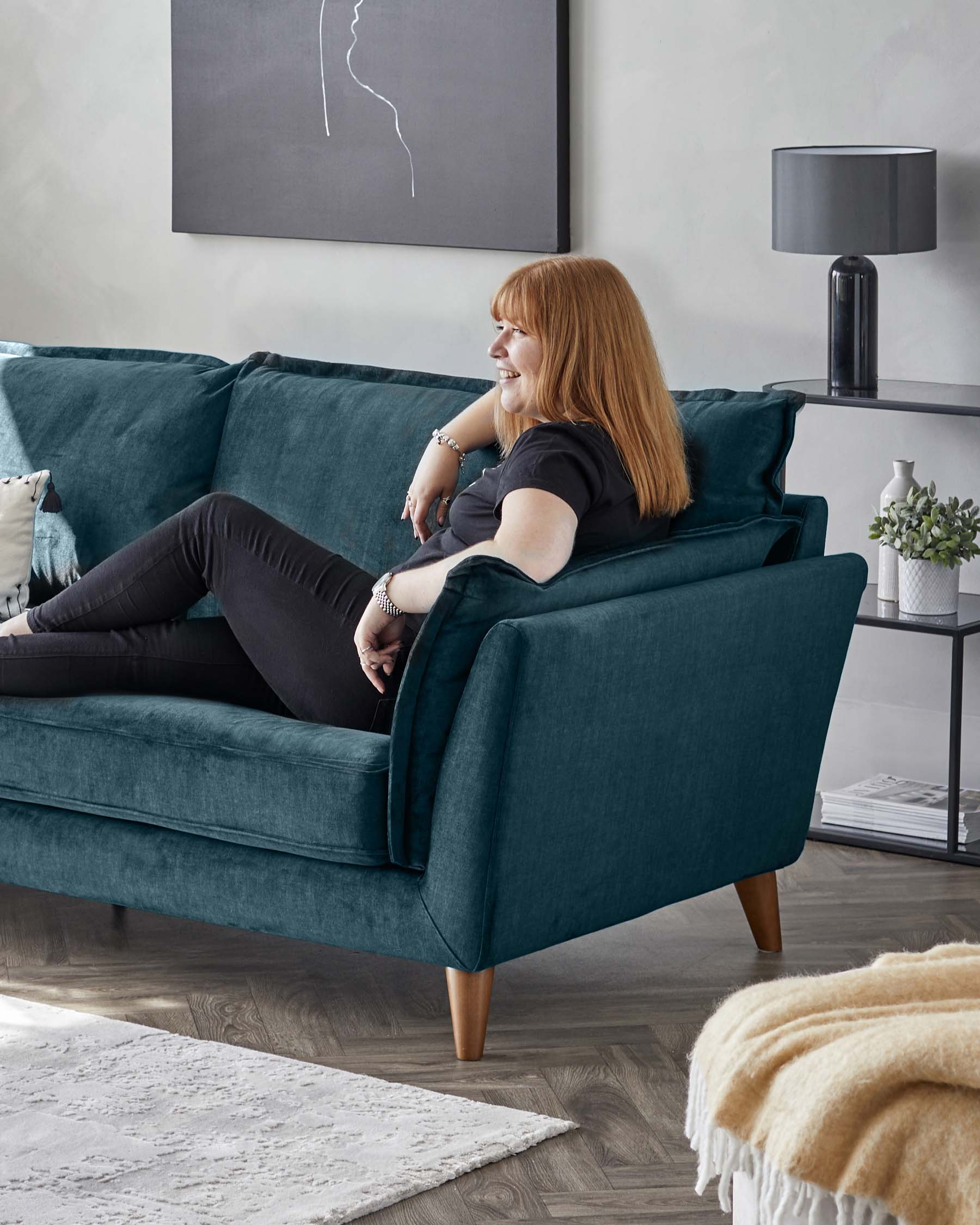 Elegant teal fabric sofa with plush cushioning and a straight, contemporary design. The couch features angled wooden legs, tufted backrests, and soft seating that offers both comfort and style.