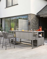 A stylish outdoor bar with a sleek gray finish, accompanied by modern high stools, perfect for entertaining.